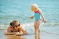 Mother and smeared with mud baby on sea beach