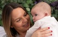 Mother smiles with her baby in her arms