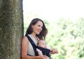 Mother smiling with infant in baby carrier