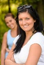 Mother smiling with teen daughter in background