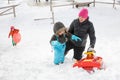 Mother snow sledding with her kids