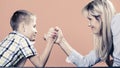 Mother and son arm wrestling.