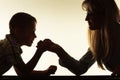 Mother and son arm wrestling.