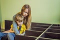 Mother and son assembling furniture. Boy helping his mom at home. Happy Family concept Royalty Free Stock Photo