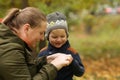 Mother and son in autumn park outdoor. Mom is care of her son. Famity activity in nature