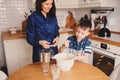 Mother and son baking cake in the kitchen. Lifestyle casual capture of family cooking