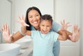 Mother and son in bathroom with clean hands, open palms that are cleaned and covered in foam teaching child hand washing Royalty Free Stock Photo