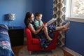 Mother with son boy sitting in armchair at home and reading book together. Child kid early development education. Family mom and Royalty Free Stock Photo