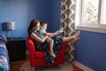 Mother with son boy sitting in armchair at home and reading book together. Child kid early development and education. Family mom Royalty Free Stock Photo