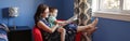 Mother with son boy sitting in armchair and reading book together. Child kid early development literacy. Family mom and baby Royalty Free Stock Photo