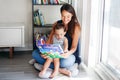 Mother with son boy sitting on floor at home and reading book together. Child kid early development education. Family mom and baby Royalty Free Stock Photo