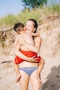 Mother and son child boy playing hugging on sand beach near sea ocean Royalty Free Stock Photo