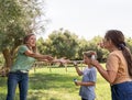 Mother, son and daughter blowing soap bubbles in a park Royalty Free Stock Photo