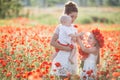 Mother, son and daughter in a field of red poppies Royalty Free Stock Photo