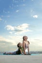 Mother and son doing exercise on the balcony in the background of a city during sunrise or sunset, concept of a healthy lifestyle Royalty Free Stock Photo