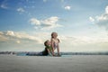 Mother and son doing exercise on the balcony in the background of a city during sunrise or sunset, concept of a healthy lifestyle Royalty Free Stock Photo