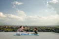 Mother and son doing exercise on the balcony in the background of a city during sunrise or sunset, concept of a healthy lifestyle Royalty Free Stock Photo