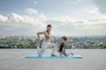 Mother and son doing exercise on the balcony in the background of a city during sunrise or sunset  concept of a healthy lifestyle Royalty Free Stock Photo