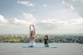 Mother and son doing exercise on the balcony in the background of a city during sunrise or sunset, concept of a healthy Royalty Free Stock Photo