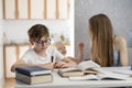 Mother and son are doing homework together. Home schooling. Tutor works with schoolboy. Teen boy studying at home Royalty Free Stock Photo