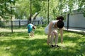 Mother and son doing yoga exercises on grass in the yard at the day time. People having fun outdoors Royalty Free Stock Photo