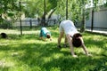 Mother and son doing yoga exercises on grass in the yard at the day time. People having fun outdoors Royalty Free Stock Photo