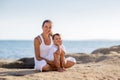 A mother and a son are doing yoga exercises at the seashore of M Royalty Free Stock Photo