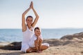 A mother and a son are doing yoga exercises at the seashore of M Royalty Free Stock Photo