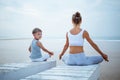 A mother and a son are doing yoga exercises at the seashore of t Royalty Free Stock Photo