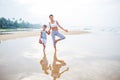 A mother and a son are doing yoga exercises at the seashore of tropic ocean Royalty Free Stock Photo