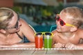 Mother and son drinking cocktails in the pool.Hot summer holidays. Royalty Free Stock Photo