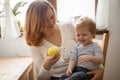 Mother and son eating an apple at the kitchen Royalty Free Stock Photo