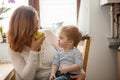 Mother and son eating an apple at the kitchen Royalty Free Stock Photo