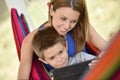 Mother and son enjoying in hammock with tablet Royalty Free Stock Photo