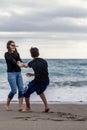 Mother and son enjoying themselves on the beach on a winter day. Vertical shot