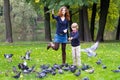 Mother and son feeding pigeons in a park Royalty Free Stock Photo
