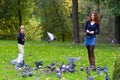 Mother and son feeding pigeons in a park Royalty Free Stock Photo