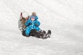 Mother and son fun slide down a snow hill on a Sunny winter`s day Royalty Free Stock Photo