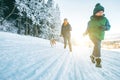 Mother and son having a fun. They running with their beagle dog in snowy forest during dog walk. Mother and son relatives and