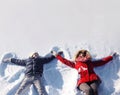 Mother and son having fun together lounging in the snow