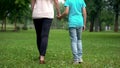 Mother and son holding hands, walking away together, concept of child adoption Royalty Free Stock Photo