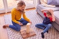 Mother And Son At Home Playing Game Stacking And Balancing Wooden Blocks Together