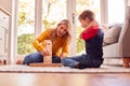 Mother And Son At Home Playing Game Stacking And Balancing Wooden Blocks Together