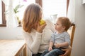 Mother and son at the kitchen eating an apple Royalty Free Stock Photo