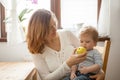 Mother and son at the kitchen eating an apple Royalty Free Stock Photo