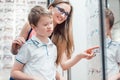 Mother and son looking for new glasses in optometrist store Royalty Free Stock Photo