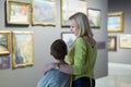 Mother and son looking at paintings in halls of museum Royalty Free Stock Photo