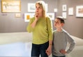 Mother and son looking at paintings in halls of museum Royalty Free Stock Photo