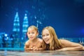 Mother and son in outdoor swimming pool with city view at night Royalty Free Stock Photo