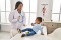 Mother and son pediatrician and patient auscultating chest at clinic Royalty Free Stock Photo